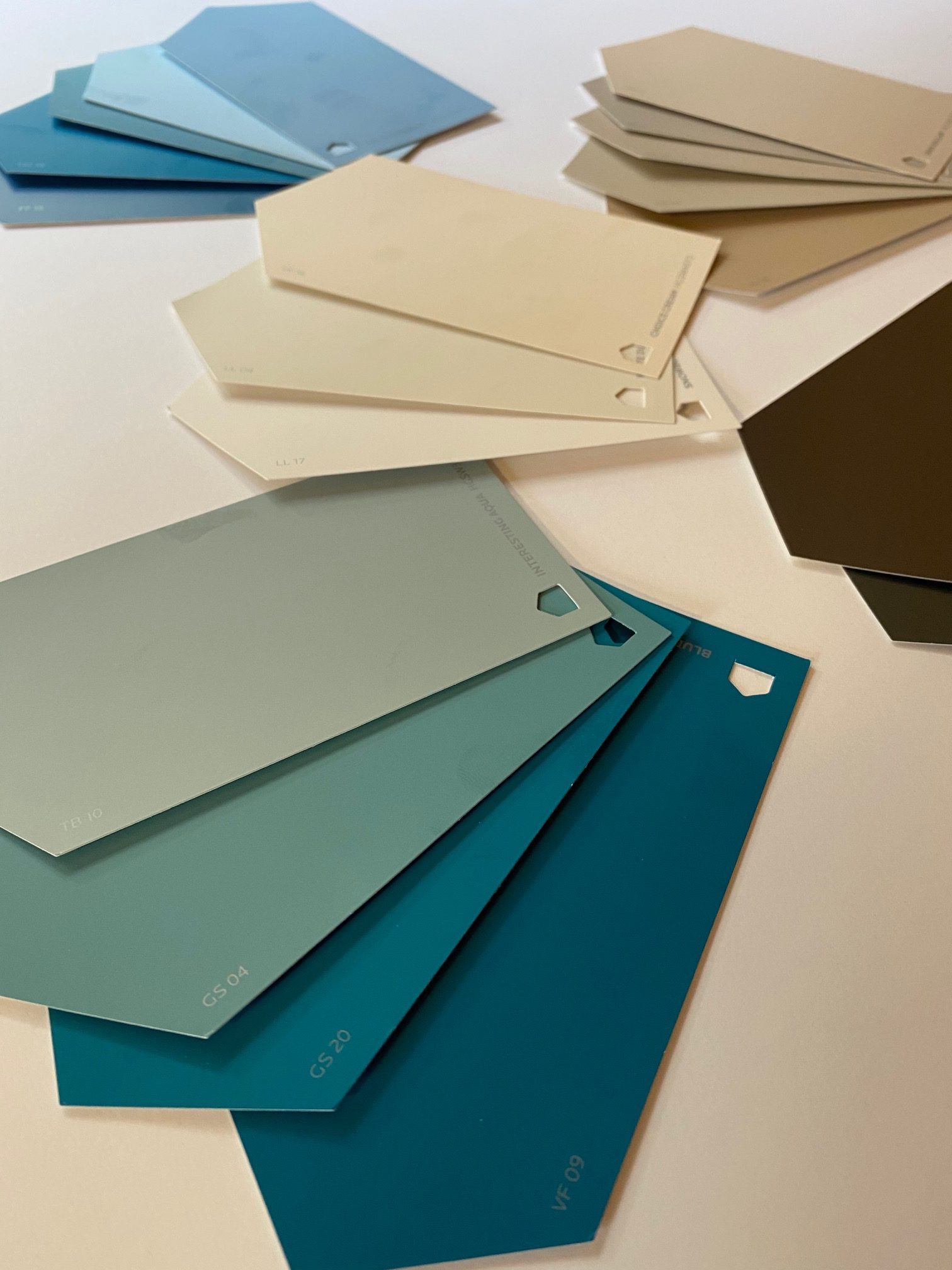 Paint swatches in the colors of teal, cream, charcoal and blue